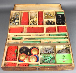 A shallow tray containing various red and green Meccano 
