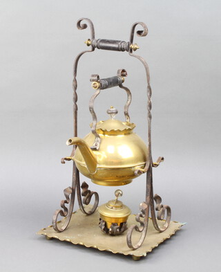 A Victorian brass and iron kettle raised on a ditto stand with spirit burner  