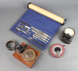 A radio tester, battery holder in a wooden case, an ammeter, a Proe precision chrome 20' tape measure and a set of cased drawing instruments 