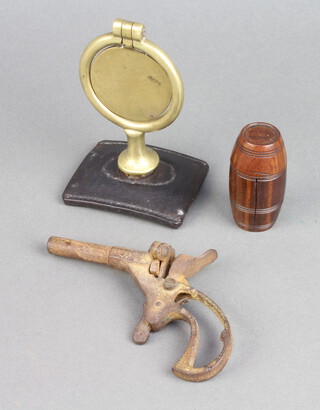 A glass inkwell contained in a carved and turned wooden barrel shaped case 5cm x 2cm, a 19th Century brass heavy horse swinger and a small pistol (f) 