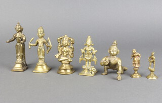 Five Eastern cast bronze figures of standing deities, raised on square bases 10cm and 8cm together with 2 polished gilt metal seals in the form of a standing lady and gentleman 6cm 
