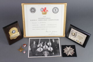 A 1958 British Transport Commission International Ambulance Competition Certificate presented to J Scrace of Horsham, framed, 22cm x 26cm, 2 British Railways Southern Region First Aid Centre Long Service plaques, a silver and enamelled blood donor's lapel badge, a St John Ambulance bronze medal, ditto enamelled lapel badge, blazer badge and a photograph of the 1958 winning team 