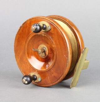 An Eaton wooden and brass star back fishing reel with brass foot 11.5cm 