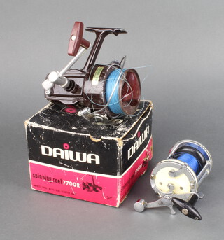 A Daiwa 7700 R spinning fishing reel boxed and with instructions together with a sea fishing reel (some corrosion in parts) 