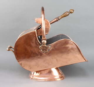 A Victorian polished copper helmet shaped coal scuttle complete with shovel 