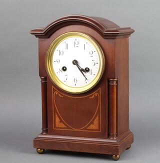 An Edwardian Art Nouveau striking bracket clock with enamelled dial and Arabic numerals contained in an arch shaped inlaid mahogany case 