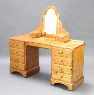 Ducal, a pine dressing table/desk fitted 1 long and 8 short drawers, raised on bracket feet 78cm h x 148cm w x 45cm d together with an associated arched plate dressing table mirror  
