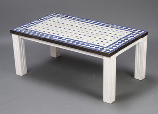 A rectangular garden table with blue and white tiled top, raised on square supports 43cm x 102cm x 61cm 