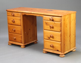 A pine desk fitted 8 drawers raised on bun feet 74cm h x 139cm w x 45cm d 