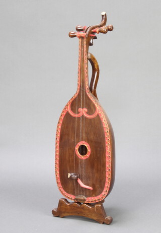 A wooden model of a 4 stringed mandolin raised on a stand 84cm x 25cm 