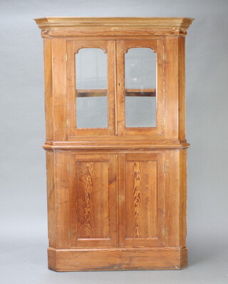 A 19th Century pine double corner cabinet with moulded cornice, fitted a shelf enclosed by arched panelled doors, the base enclosed by pair of panelled doors 178cm h x 104cm w x 67cm d (there is no back to this cabinet) 