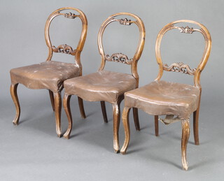 A set of 3 Victorian carved and pierced mahogany balloon back dining chairs with pierced mid rails on cabriole supports 