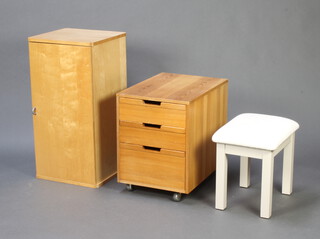 A pine chest of 3 drawers 56cm h x 42cm w x 59cm d together with a beech cabinet enclosed by a panelled door 82cm h x 42cm w x 39cm d and a white finished dressing table stool 43cm x 44cm x 32cm 