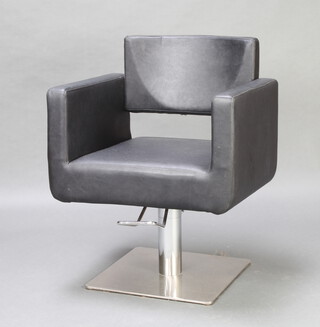 A chrome and black rexine revolving and adjustable barbers seat