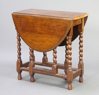 A 1930's oak oval drop flap gateleg dining table, raised on spiral turned supports 74cm h x 74cm w x 38cm d 