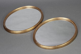 A pair of 19th Century style oval plate wall mirrors contained in decorative gilt frames 50cm x 42cm 