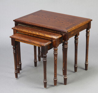 A nest of 3 oak interfitting coffee tables raised on turned supports 76cm h x 54cm w x 39cm d together with a circular walnut coffee table (signs of old but treated worm) and a standard lamp 