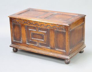 A 1930's carved oak coffer with hinged lid raised on bun feet 52cm h x 92cm w x 49cm d