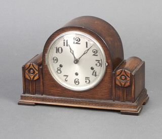 An Art Deco chiming mantel clock with silvered dial and Arabic numerals contained in an oak case 