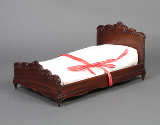 A carved hardwood dolls bed 24cm x 15cm x 30cm 