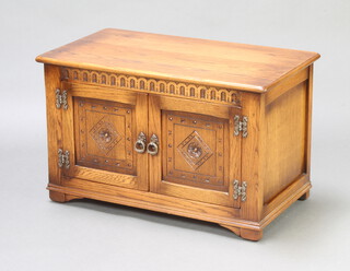 A carved oak record cabinet enclosed by panelled doors with arcaded decoration on bracket feet 50cm h x 81cm w x 45cm d 