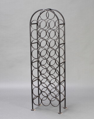 A black painted, arch shaped, wrought metal 29 bottle wine rack 109cm h x 32cm w x 21cm d 