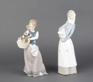 A Lladro figure of a girl holding a lamb 28cm, ditto of a girl holding a basket of puppies 23cm 