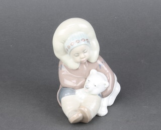 A Lladro figure of a seated Eskimo child and polar bear cub 12cm 