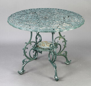 A circular green painted pierced aluminium garden table raised on cabriole supports 67cm h x 89cm diam. 