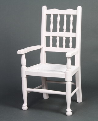 A childs pink painted elm spindle back open armchair with woven rush seat 
