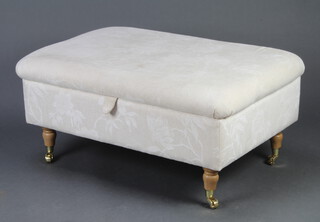 A Victorian style ottoman upholstered in white material, raised on turned supports with brass caps and castors 42cm h x 94cm w x 66cm d 