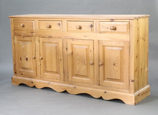A Victorian style pine dresser base fitted 4 drawers above a pair of double cupboards raised on a shaped apron 90cm h x 175cm w x 42cm d  