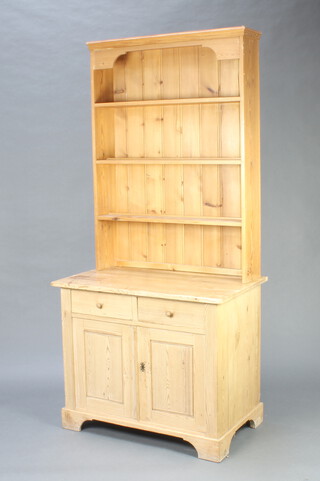 A Continental pine dresser, the associated raised back with moulded cornice and 3 shelves, the base with 2 drawers above a double cupboard, raised on a platform base 201cm h x 94cm w x 57cm d 