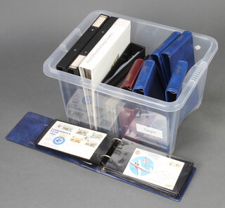 A collection of empty stamp albums in a white plastic crate 
