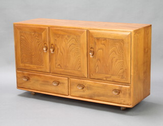 Ercol, a Windsor light elm sideboard fitted 3 cupboards above 2 drawers, raised on casters, 76cm h x 129cm w x 43cm d 