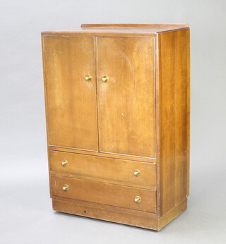A 1930's oak tallboy, the upper section with raised back, enclosed by panelled doors, base fitted 2 drawers 123cm h x 82cm w x 45cm h 
