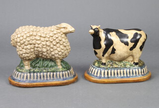 A crackle glazed ceramic figure of a sheep, ditto Friesian cow, on oval bases 23cm 