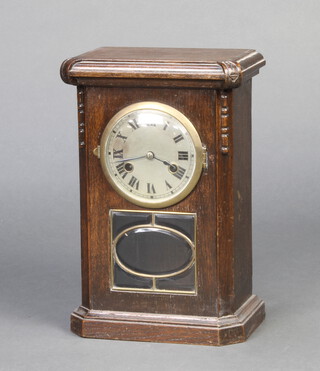 A 1930's striking mantel clock with silvered dial and Roman numerals contained in an oak case 
