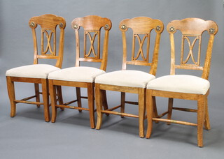 A set of 4 Regency style mango wood bar back dining chairs with pierced slat backs and over stuffed seats, raised on outswept supports 
