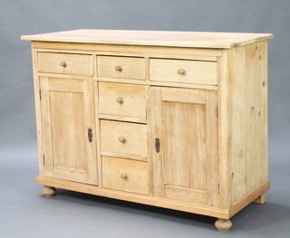 A 19th Century Continental stripped pine dresser base fitted 3 frieze drawers with tore handles above 3 drawers flanked by cupboards, raised on bun feet 96cm h x 130cm w x 58cm d  