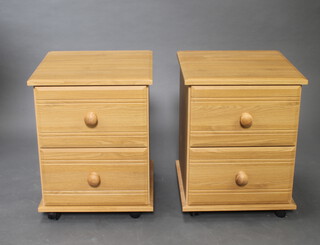 A pair of light wood grain laminate finished bedside chests of 2 drawers 49cm h x 41.5cm x 41.5cm 