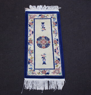 A blue and white ground Chinese rug 128cm x 62cm 