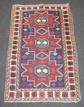A red, white and blue ground Afghan rug with 3 stylised diamonds to the centre within a multi row border 183cm x 111cm 