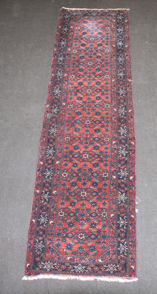 A red and blue ground floral patterned Persian runner with a 3 row border 293cm x 79cm 