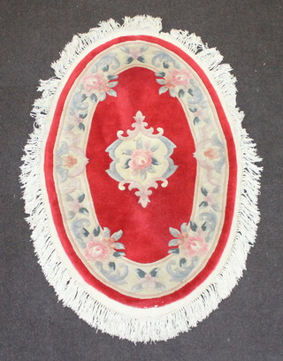 An oval red and white floral patterned Indian rug 131cm x 323cm 
