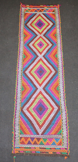 A brown, orange, purple and green ground Suzni Kilim runner with 4 stylised diamonds to the centre 266cm x 63cm 