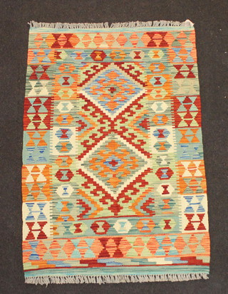 A green, tan and yellow ground Chobi Kilim rug with 2 diamonds to the centre and all over geometric designs 113cm x 78cm 