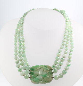A good Chinese carved jade necklace with triple bead strands and a rectangular plaque carved with a shi shi, 36cm 
