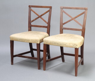 A pair of Georgian mahogany dining chairs with X framed backs and over stuffed seats raised on square supports with H framed stretchers 