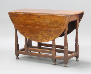 An 18th Century oak oval drop flap gateleg dining table fitted a frieze drawer, raised on turned supports 71cm h x 106cm w x 38cm when closed x 113cm when open 